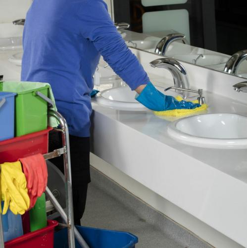 rubber gloved hand cleaning sink with duster